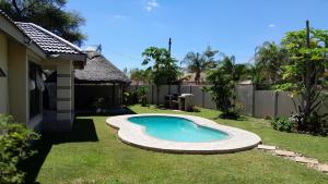 a small swimming pool in the yard of a house at The Rock BnB in Francistown
