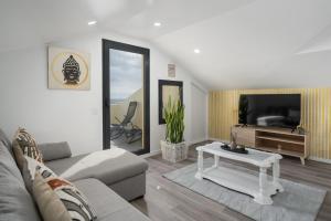 a living room with a couch and a tv and a table at Casa Jorge Calaça by An Island Apart in Caniçal