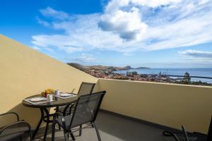 a table and chairs on a balcony with a view of the ocean at Casa Jorge Calaça by An Island Apart in Caniçal