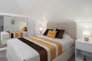 a white bedroom with two beds and a mirror at Casa Jorge Calaça by An Island Apart in Caniçal