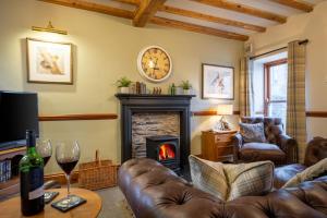 a living room with a couch and a fireplace at Smithy Cottage in Hawkshead