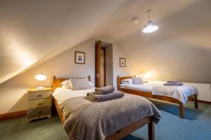 a bedroom with two beds in a attic at Smithy Cottage in Hawkshead