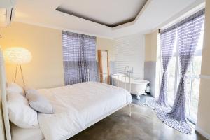 a bedroom with a bed and a tub and windows at Jeju Semo, Byeol in Seogwipo +23 photos