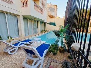 a patio with chairs and a swimming pool at قصر فنيسيا 6غرف للإيجار ViP Vienice Palace luxury in 6th Of October +25 photos