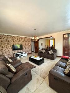 a large living room with couches and a tv at Rhacky Homes - Near JKIA & SGR in Nairobi