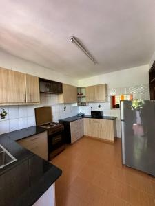 a kitchen with wooden cabinets and a stainless steel refrigerator at Rhacky Homes - Near JKIA & SGR in Nairobi