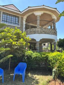 a house with two blue chairs in front of it at Rhacky Homes - Near JKIA & SGR in Nairobi