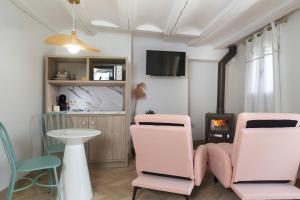 a living room with pink chairs and a fireplace at 40 de Mayo in Cantavieja