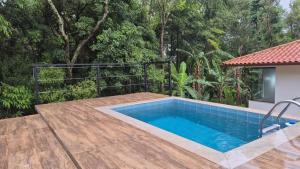 a swimming pool with a wooden deck at A Casinha Lumiar in Lumiar