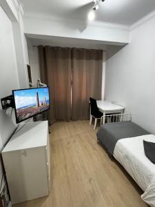 a bedroom with a bed and a desk with a television at Quarto individual perto de Lisboa e Sintra in Queluz