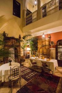 a large room with tables and plants in it at Riad Light Of Sun in Marrakech