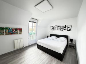a white bedroom with a bed and a window at Disney Avengers House in Magny-le-Hongre