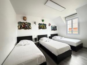 two beds in a room with white walls at Disney Avengers House in Magny-le-Hongre