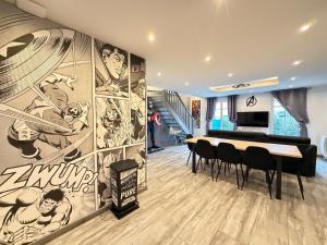 a dining room with a large painting on the wall at Disney Avengers House in Magny-le-Hongre