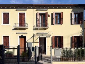 a white house with brown doors and a fence at Venice Entry Comfort Apartment in Mestre