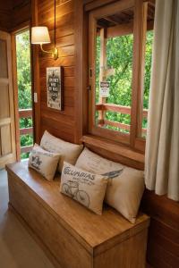 a bench with pillows in a room with a window at Cabanas Green Valley in Monte Verde