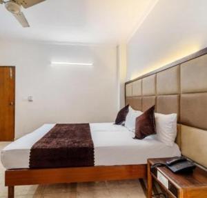 a bedroom with a large bed with a wooden headboard at Hotel Atithi Residency in Lucknow +17 photos