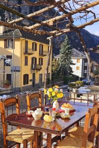 a wooden table with flowers on top of a patio at Alpine View Varzo - Train Station in Varzo