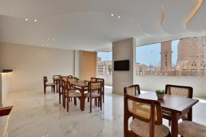 a dining room with tables and chairs and a television at Horizon Pyramids Boutique in Cairo