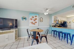 a dining room with a table and chairs and a kitchen at Plantation Palms 6305 in Gulf Highlands