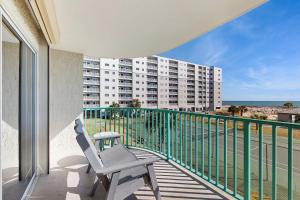 a balcony with a chair and a view of a building at Plantation Palms 6305 in Gulf Highlands