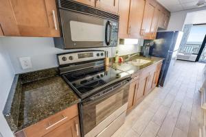 a kitchen with a stove and a microwave at Prime Ocean Frontage The Pavilion in Myrtle Beach +47 photos