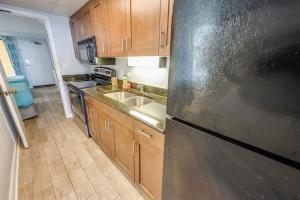 a kitchen with wooden cabinets and a stainless steel refrigerator at Prime Ocean Frontage The Pavilion in Myrtle Beach