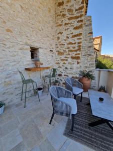 a patio with chairs and tables and a stone wall at 40 de Mayo in Cantavieja