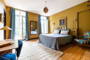 a bedroom with yellow walls and a bed and a chair at chalet baron in Lormont +18 photos
