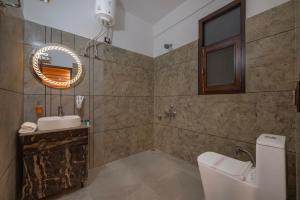 a bathroom with a sink and a toilet and a mirror at Evening Sky Hotel - Kasauli !!! in Kasauli