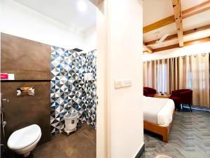 a bathroom with a toilet and a bed in a room at The Grand Dwaper A- Luxury Rooms & Parking Walking Distance From Mall Road in Mussoorie