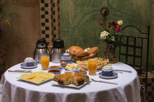 a table with a white table cloth with food and drinks at Riad Light Of Sun in Marrakech