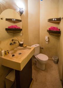 een badkamer met een wastafel, een toilet en een spiegel bij Riad Light Of Sun in Marrakesh