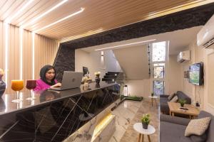 a woman sitting at a counter with a laptop at Horizon Pyramids Boutique in Cairo
