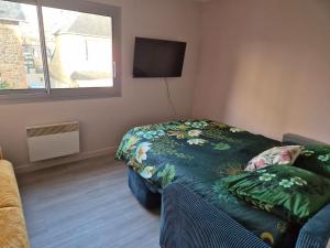 a bedroom with a bed and a flat screen tv at Ty Joty in Perros-Guirec