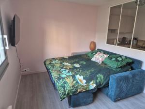 a bedroom with a bed and a blue couch at Ty Joty in Perros-Guirec