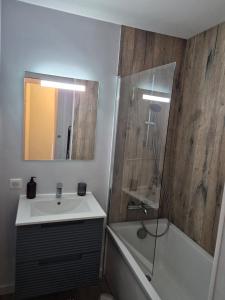 a bathroom with a sink and a tub and a mirror at Ty Joty in Perros-Guirec