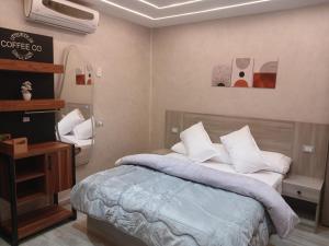 a bedroom with a bed with pillows and a television at Elmandara Residence in Alexandria