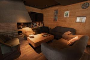 a living room with couches and a coffee table at Hôtel Le P'tit Cham, au pied du Sancy in Le Mont-Dore