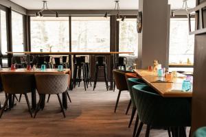 a restaurant with wooden tables and chairs and windows at Hôtel Le P'tit Cham, au pied du Sancy in Le Mont-Dore +48 photos