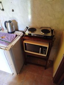 a small kitchen with a stove and a microwave at Complejo Kallpa in Santiago del Estero