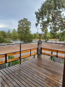 a wooden boardwalk with a statue on a fence at El Pedregullo in Neuquén +3 photos