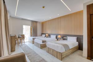 a hotel room with two beds and a desk at Horizon Pyramids Boutique in Cairo +86 photos