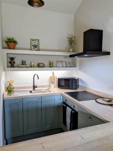 a kitchen with blue cabinets and a sink at Pudsey Loft Apartment in Pudsey +9 photos