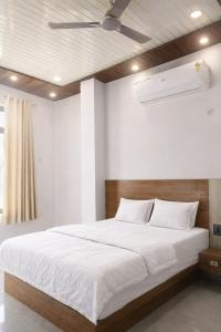 a bedroom with a large bed with a ceiling fan at The Shree Ganesh Hotel in Khātu