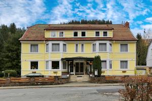 a large yellow house with a red roof at Pension Haus Sonneck in Wildemann