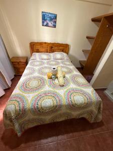 a bed with a quilt and two teddy bears on it at Hotel LaLoma in San Miguel Regla