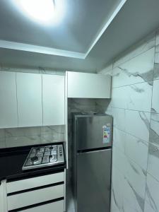 a kitchen with a stove and a refrigerator at yallah surf house in Taghazout