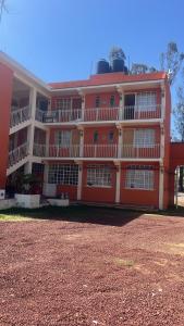 a large orange building with a lot of windows at Hotel LaLoma in San Miguel Regla