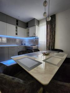 a kitchen with a large white table and chairs at Apartments Bulatovic in Budva